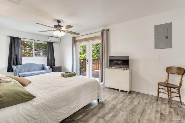 bedroom with a wall mounted AC, wood finished floors, access to outside, electric panel, and baseboards