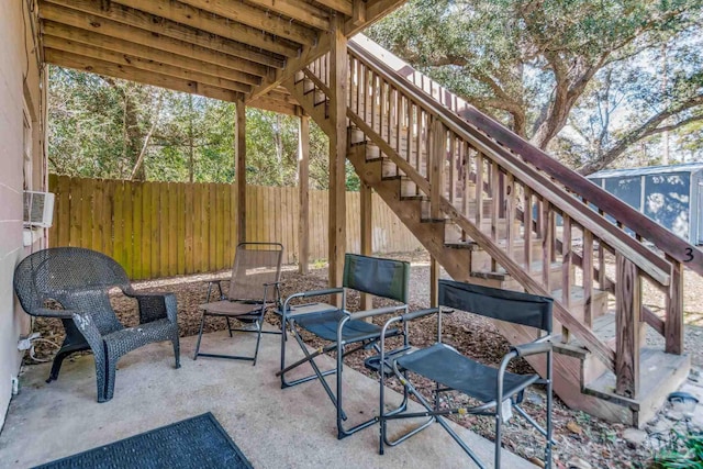 view of patio featuring stairway and fence