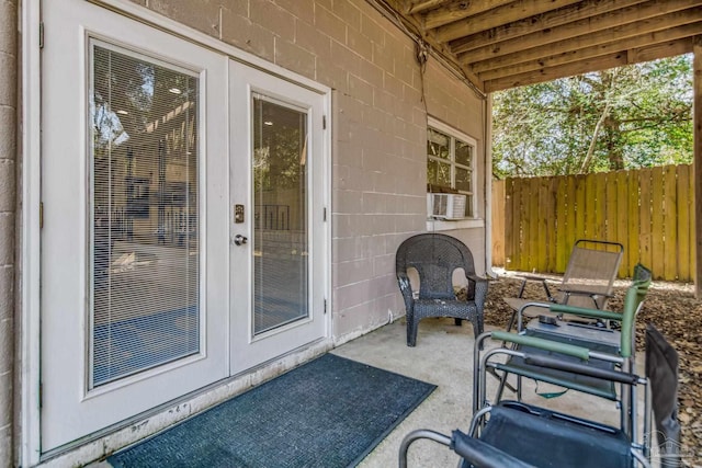 view of patio / terrace with french doors, cooling unit, and fence