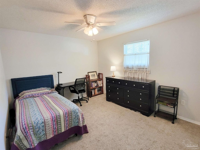 carpeted bedroom with a ceiling fan and a textured ceiling