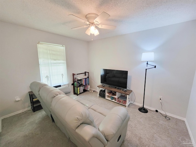 living room featuring ceiling fan, carpet, baseboards, and a textured ceiling