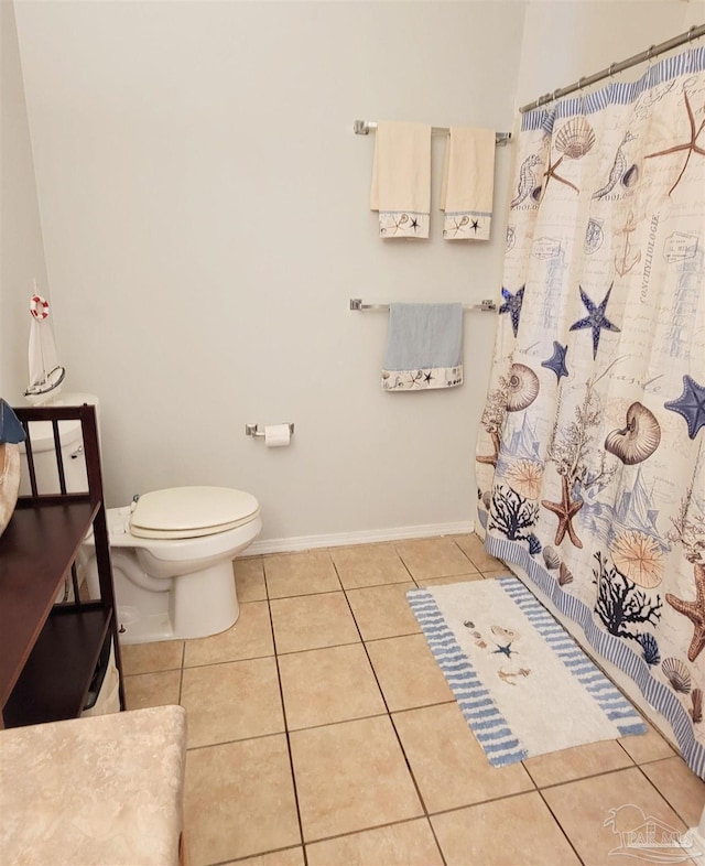 bathroom featuring toilet, tile patterned floors, a shower with curtain, and baseboards