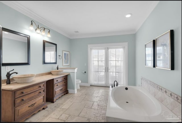 bathroom featuring a tub to relax in, french doors, ornamental molding, and toilet