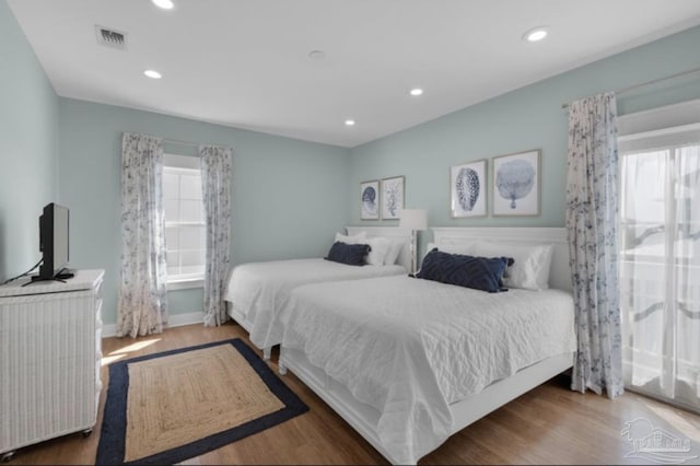 bedroom featuring dark hardwood / wood-style flooring and multiple windows