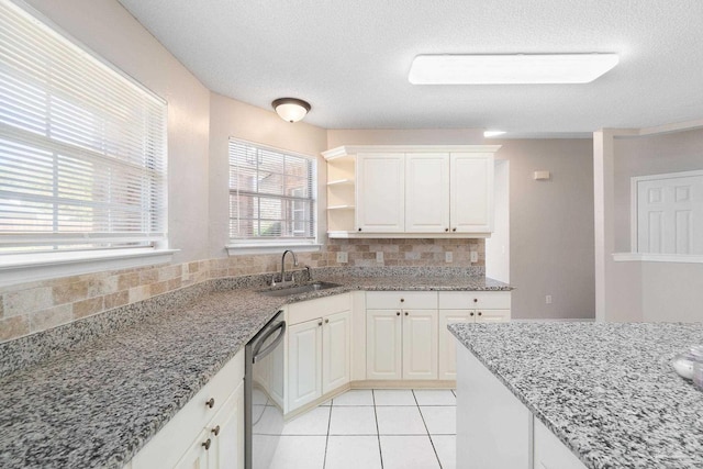 kitchen with a sink, white cabinetry, decorative backsplash, light stone countertops, and dishwasher