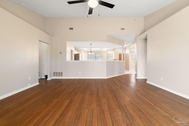 unfurnished living room with visible vents, baseboards, and wood finished floors