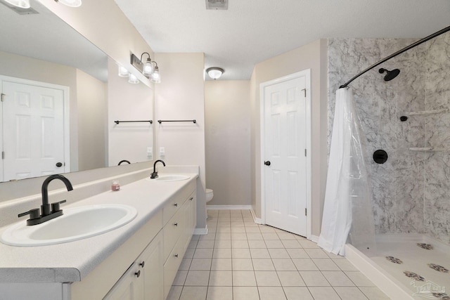 full bath with a sink, a shower stall, toilet, and double vanity