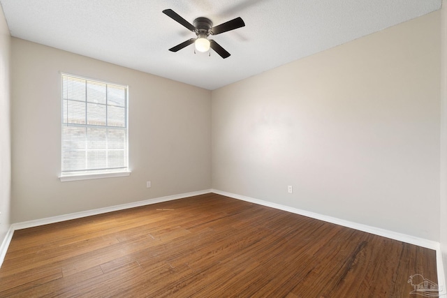 empty room featuring ceiling fan, a textured ceiling, baseboards, and wood finished floors