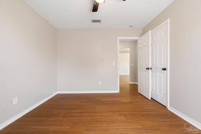 unfurnished room featuring visible vents, baseboards, and wood finished floors