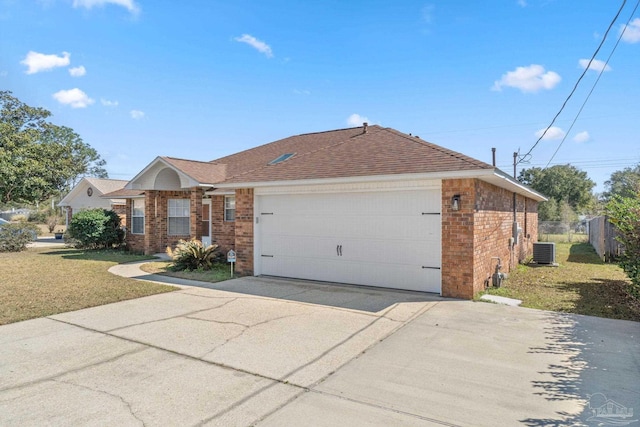 ranch-style house with central AC unit, an attached garage, brick siding, concrete driveway, and a front yard