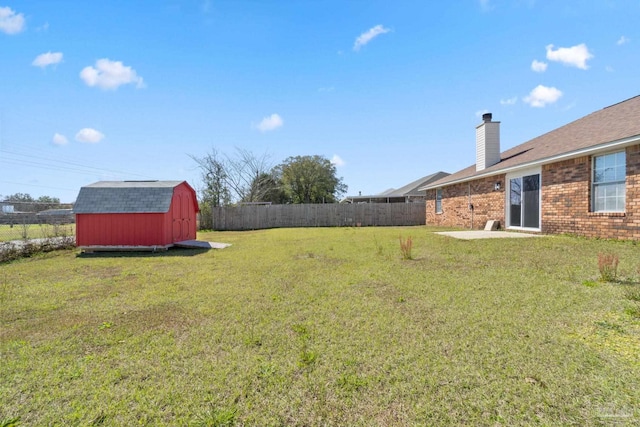 view of yard with an outbuilding, a shed, and fence