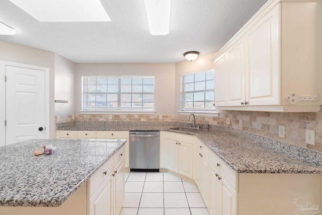 kitchen featuring light tile patterned flooring, a sink, decorative backsplash, light stone countertops, and dishwasher