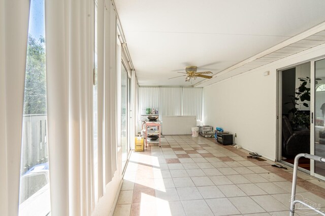 unfurnished sunroom featuring ceiling fan