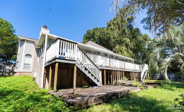 back of house with a deck and a yard