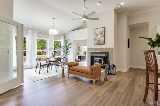 living room with lofted ceiling, baseboards, ceiling fan, wood finished floors, and a fireplace