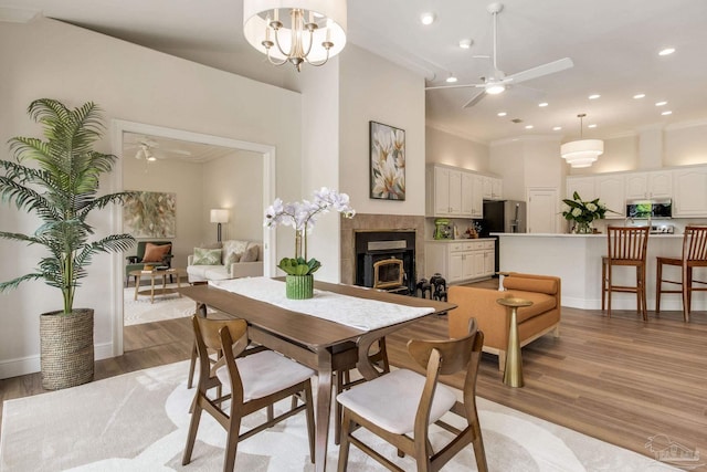 dining space featuring ornamental molding, a ceiling fan, and light wood-style floors
