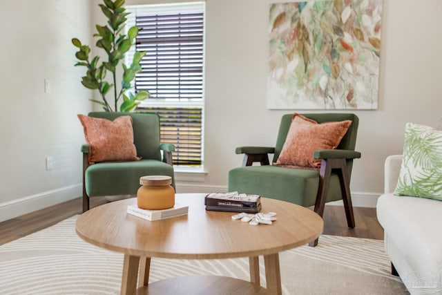 sitting room with baseboards and wood finished floors