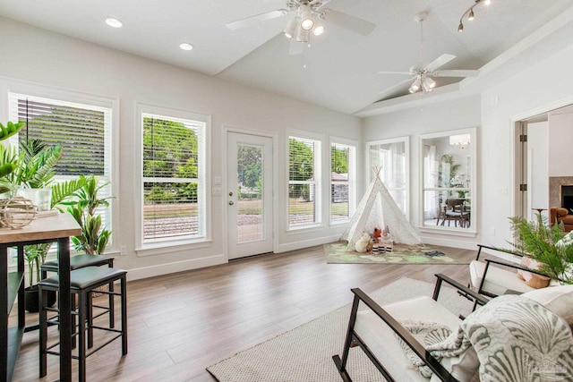sunroom / solarium featuring wood finished floors, lofted ceiling, a healthy amount of sunlight, and recessed lighting