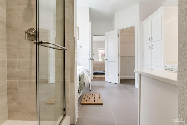 full bathroom with tile patterned floors, ensuite bath, a stall shower, and a spacious closet