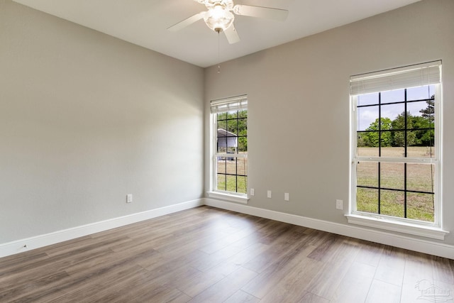 unfurnished room featuring ceiling fan, baseboards, and wood finished floors