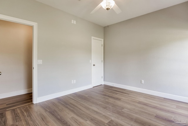 spare room featuring ceiling fan, baseboards, and wood finished floors