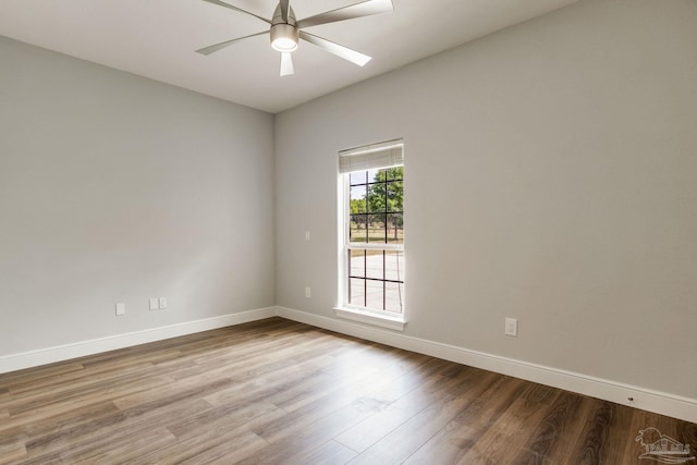 spare room featuring baseboards, ceiling fan, and wood finished floors
