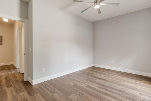 empty room featuring a ceiling fan, baseboards, and wood finished floors