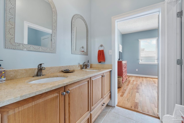 bathroom with dual vanity and wood-type flooring