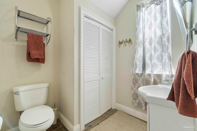 bathroom featuring tile patterned flooring, toilet, vanity, and a textured ceiling