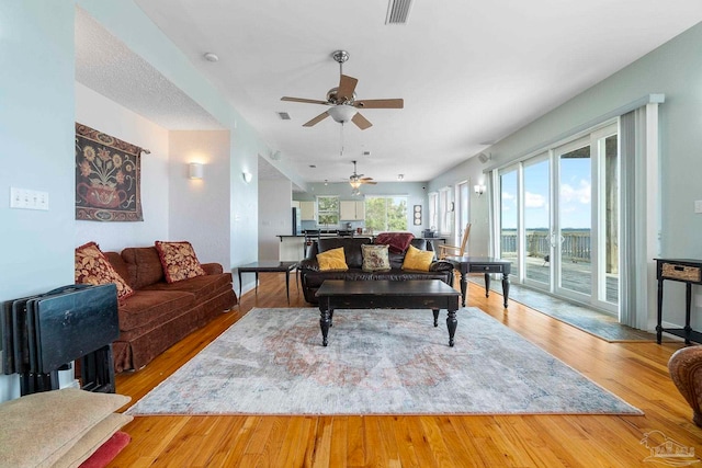 living room featuring ceiling fan and light hardwood / wood-style flooring