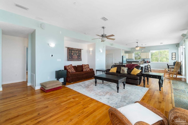 living room with ceiling fan and light hardwood / wood-style floors