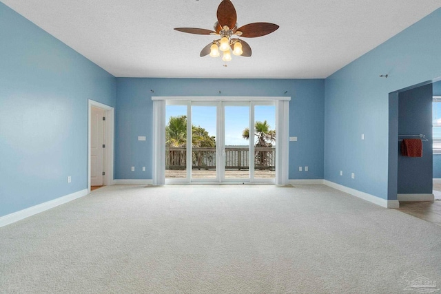 empty room featuring carpet floors, a textured ceiling, and ceiling fan