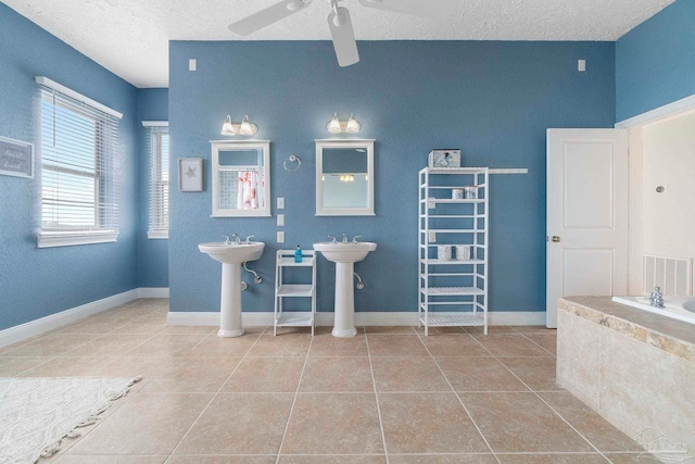 bathroom featuring tile patterned floors, a textured ceiling, ceiling fan, and a bath