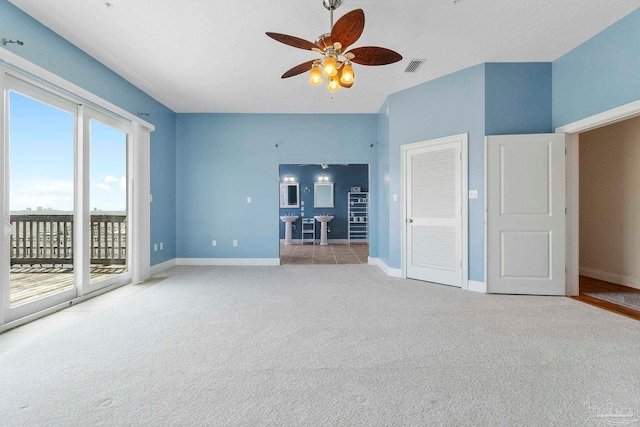 unfurnished living room with light carpet and ceiling fan