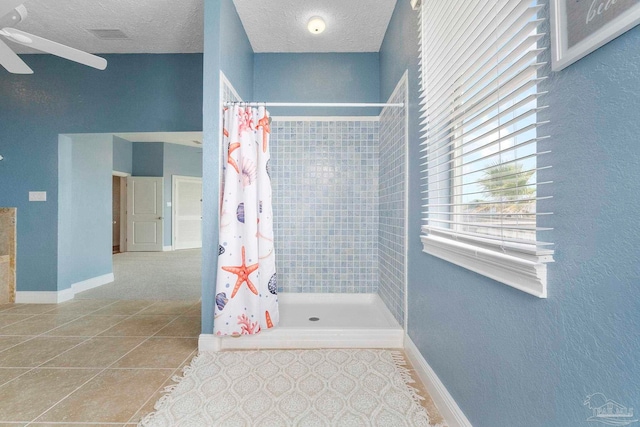 bathroom featuring curtained shower, a textured ceiling, tile patterned flooring, and ceiling fan