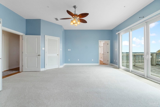 unfurnished bedroom featuring light carpet, access to outside, and ceiling fan