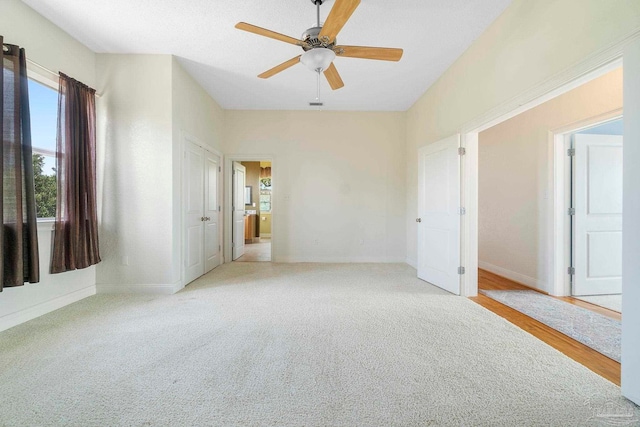 empty room with light colored carpet and ceiling fan