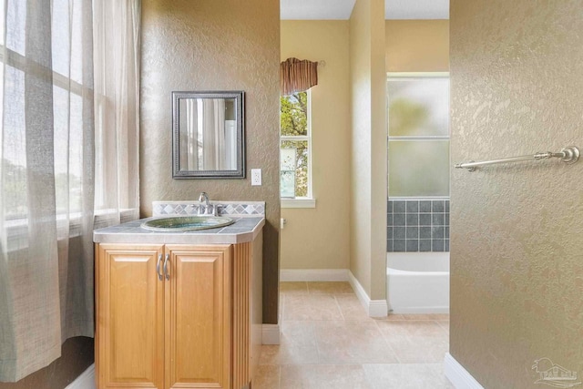 bathroom featuring tile patterned floors, a tub to relax in, and vanity