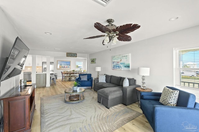 living room featuring light wood-type flooring and ceiling fan