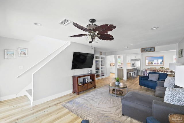 living room featuring ceiling fan and light hardwood / wood-style floors