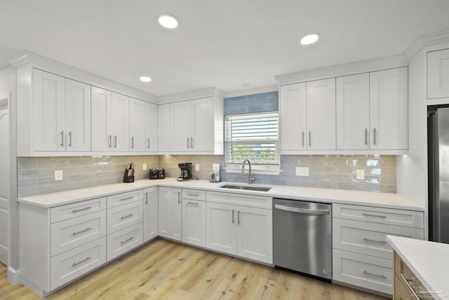 kitchen featuring sink, stainless steel appliances, and white cabinetry