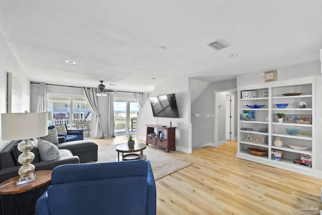 living room with light wood-type flooring and ceiling fan