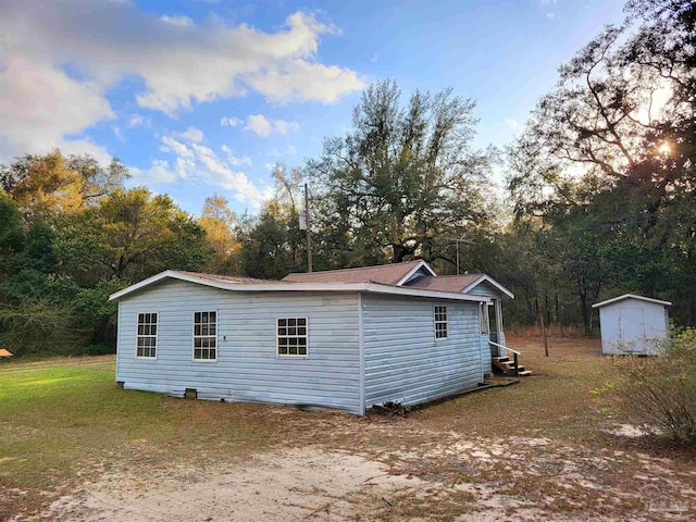 exterior space featuring an outbuilding, a storage unit, and a yard