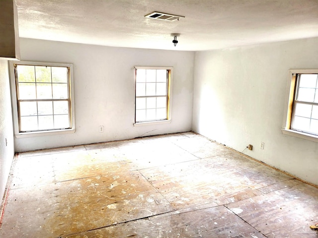 unfurnished room with visible vents and a textured ceiling