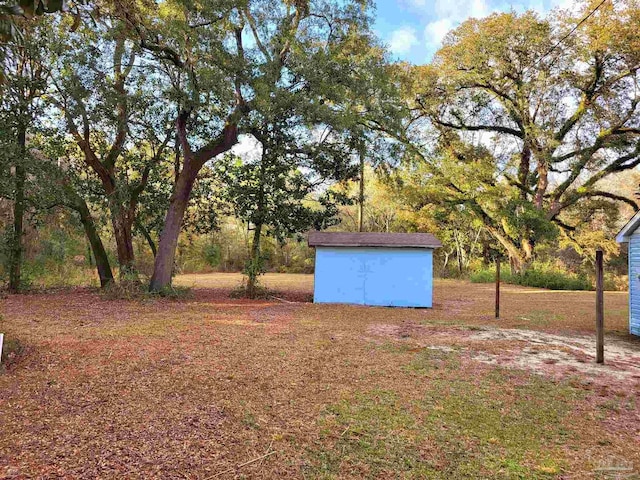 view of yard featuring an outbuilding and a storage shed