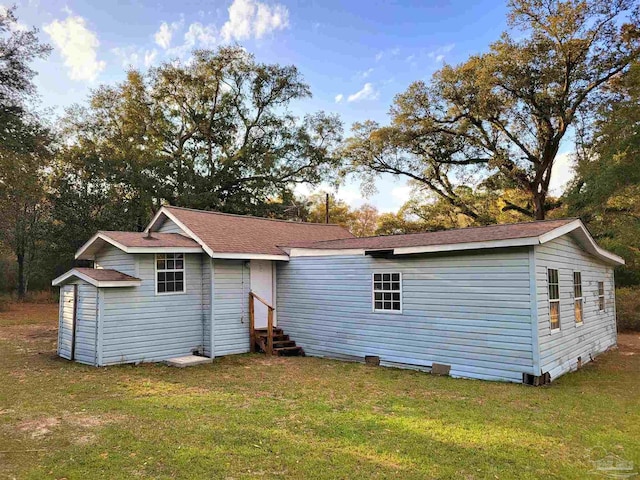 back of house featuring entry steps and a yard