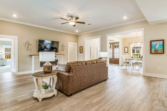 living room featuring ceiling fan with notable chandelier, crown molding, and light hardwood / wood-style flooring