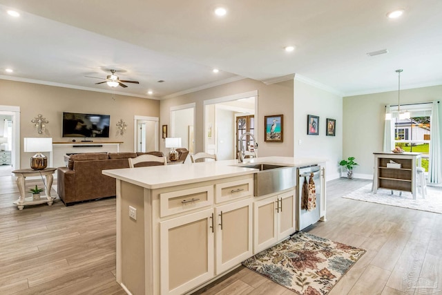 kitchen with sink, decorative light fixtures, stainless steel dishwasher, a kitchen island with sink, and light wood-type flooring