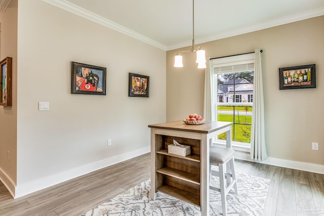 dining area with a chandelier, light hardwood / wood-style floors, and crown molding