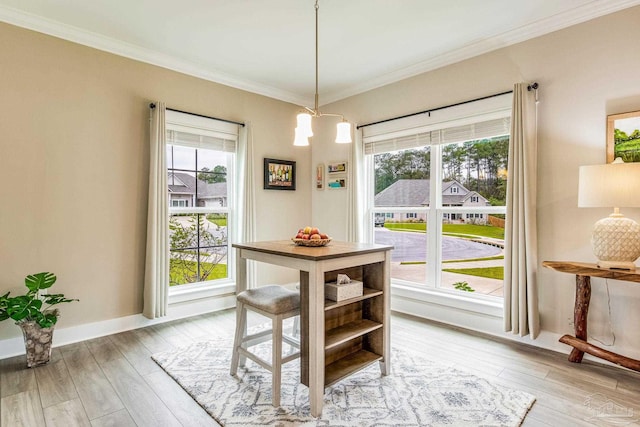 dining area featuring light wood-type flooring, plenty of natural light, and crown molding